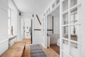 a hallway with white walls and a wooden door at H.C. Andersens hang around in Copenhagen
