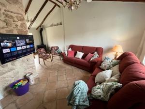 a living room with a couch and a tv at Las Casas del Rincón- 7 dormitorios in Villahermosa