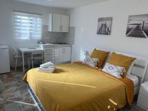a bedroom with a yellow bed and a kitchen at Finca La Luz in San Miguel de Abona