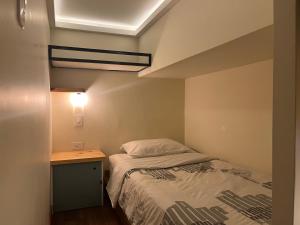 een kleine slaapkamer met een bed en een bureau bij The Cranky Croc Hostel in Bogota