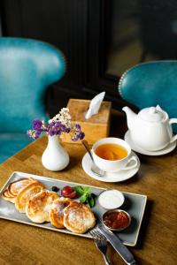 einen Tisch mit einem Teller Essen und einer Tasse Tee in der Unterkunft Frapolli Hotel in Odessa