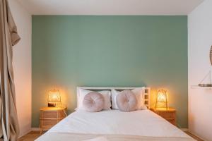 um quarto com uma cama branca e 2 almofadas em The Priest's Home by LovelyStay no Porto
