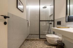 y baño con ducha, aseo y lavamanos. en The Priest's Home by LovelyStay en Oporto