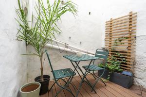 una mesa y 2 sillas en un balcón con plantas en The Priest's Home by LovelyStay en Oporto