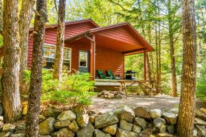 a small cabin in the woods with a stone wall at Mersey River Chalets a nature retreat in Caledonia