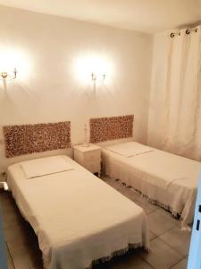 twee bedden in een kamer met witte muren bij Le Médicis - Centre village calme in Bessan