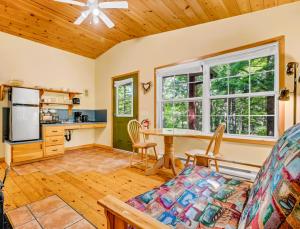 eine Küche und ein Wohnzimmer mit einem Tisch und einem Sofa in der Unterkunft Mersey River Chalets a nature retreat in Caledonia