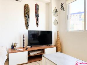 a living room with a flat screen tv on a table at Lindo al Mar con Piscina/Tenis in Benicàssim