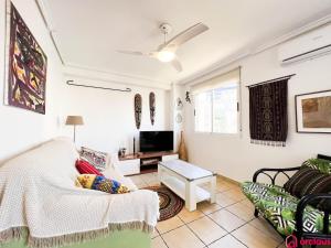 a living room with a couch and a tv at Lindo al Mar con Piscina/Tenis in Benicàssim