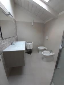 een witte badkamer met 2 toiletten en een wastafel bij CASA LAVANDA in Rivoli