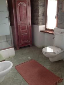 een badkamer met een wit toilet en een wastafel bij Casale La Selva Cottege grande in Piano Porlezza