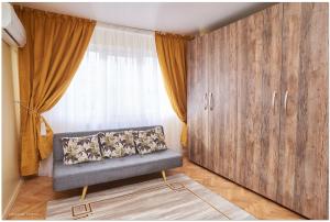 ein Wohnzimmer mit einem Sofa und einem großen Fenster in der Unterkunft Star Apartment in Timişoara