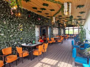 restauracja z zieloną ścianą ze stołami i krzesłami w obiekcie Relax w mieście Greci
