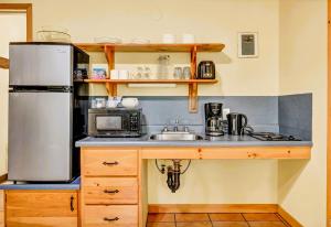 a kitchen with a sink and a refrigerator at Mersey River Chalets a nature retreat in Caledonia