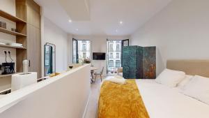 ein weißes Schlafzimmer mit einem weißen Bett und einem Schreibtisch in der Unterkunft Santa Cruz in Madrid