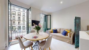 ein Wohnzimmer mit einem Tisch und einem Sofa in der Unterkunft Santa Cruz in Madrid