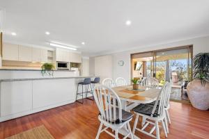 a kitchen and dining room with a table and chairs at Magnolia Sea Views in Mandurah