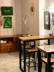 a dining room with two tables and stools at Hôtel Colisée-Verdun Centre Gare Saint-Roch in Montpellier