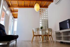 ロスピタレート・デ・リョブレガートにあるMarBarcelona Apartments Mas At bのダイニングルーム(テーブル、椅子、テレビ付)