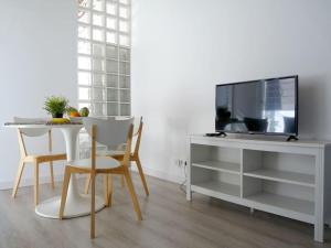 a living room with a table and a tv and a desk at MarBarcelona Apartments Mas At b in Hospitalet de Llobregat