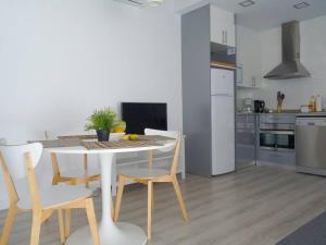 a kitchen with a white table and chairs in a room at MarBarcelona Apartments Mas At b in Hospitalet de Llobregat