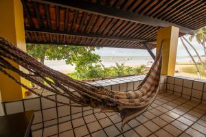 uma rede de descanso num quarto com vista para a praia em Odoiá Maragogi Restaurante e Estalagem em Maragogi