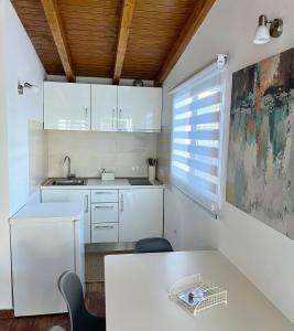 a kitchen with white cabinets and a table at Finca La Luz in San Miguel de Abona