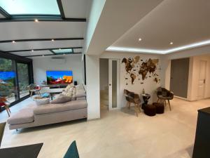 a living room with a couch and a flat screen tv at Villa Miramar Near Disneyland Paris in Annet-sur-Marne