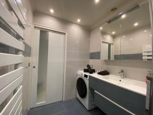 a bathroom with a washing machine and a sink at Villa Miramar Near Disneyland Paris in Annet-sur-Marne