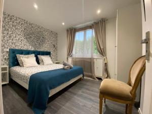 a bedroom with a blue bed and a chair at Villa Miramar Near Disneyland Paris in Annet-sur-Marne