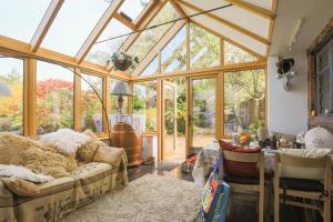 a living room with a conservatory with glass windows at Finest Retreats - The Ratcatchers Cottage 