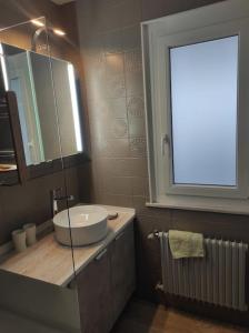 a bathroom with a sink and a large window at Petit paradis cocooning avec balcon à Torgon in Vionnaz