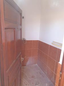 La salle de bains est pourvue d'une porte et de carrelage. dans l'établissement ATFIL CAMP, à M'Hamid El Ghizlane