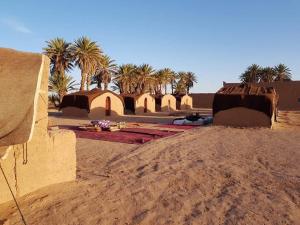 un désert avec des palmiers et un groupe de bâtiments dans l'établissement ATFIL CAMP, à M'Hamid El Ghizlane