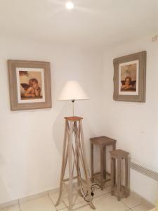 um candeeiro num quarto com duas fotografias na parede em L'Olivier - Centre village - Au calme em Bessan