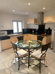 a kitchen with a glass table and two chairs at L'Olivier - Centre village - Au calme in Bessan