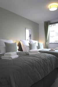 - une chambre avec un grand lit et des oreillers blancs dans l'établissement 80 m2 l Central lWLAN lNetflix l MuYa Apartments, à Hanovre