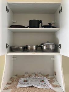 una cocina con algunas ollas y sartenes en un estante en Apartamento em condomínio Belém en Belém