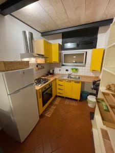 フィレンツェにあるCasa La Porta Rossaのキッチン(黄色のキャビネット、白い冷蔵庫付)