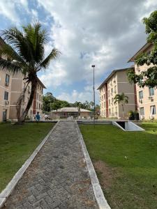 a park with a palm tree and two buildings at Apartamento em condomínio Belém in Belém
