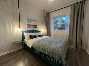 a bedroom with a blue bed and a window at Central Welling Flat in Welling