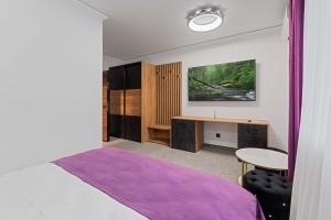 a bedroom with a bed and a desk and a table at Fit Residence in Cluj-Napoca
