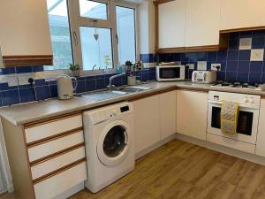 a kitchen with a washing machine and a sink at Cosy Stay in the Heart of Dover in Kent