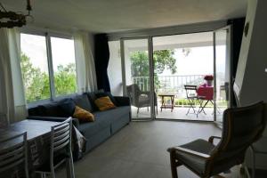uma sala de estar com um sofá azul e uma varanda em Casa Yves em Tossa de Mar