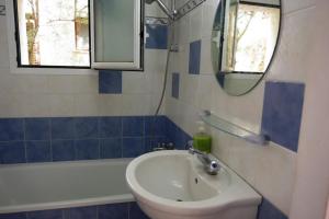een badkamer met een wastafel, een bad en een spiegel bij Casa Yves in Tossa de Mar