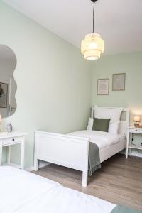 ein weißes Schlafzimmer mit einem weißen Bett und einem Schreibtisch in der Unterkunft 80 m2 l Central lWLAN lNetflix l MuYa Apartments in Hannover