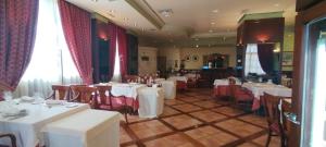 una sala da pranzo con tavoli bianchi e sedie rosse di Hotel Conde Ansúrez a Valladolid