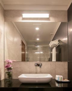 a bathroom with a sink and a large mirror at Rococo Residence in Colombo