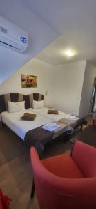 a bedroom with a large bed and a red chair at Relax in Greci