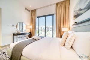 een slaapkamer met een groot wit bed en een raam bij Luxury 4BR Villa with Assistant’s Room Al Dana Island, Fujairah by Deluxe Holiday Homes in Fujairah